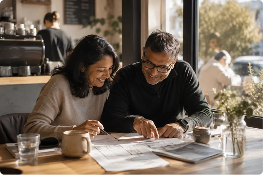A couple working out what their home is worth over floor plans
